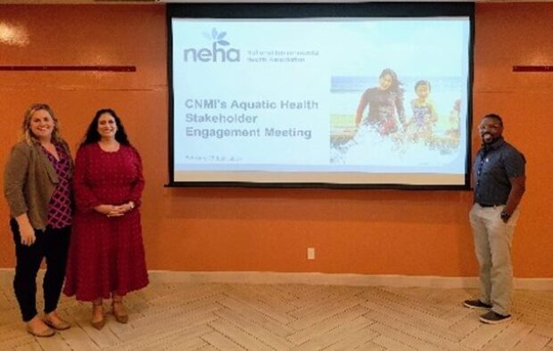 3 people standing by presentation to gather input on CNMI's aquatic safety code