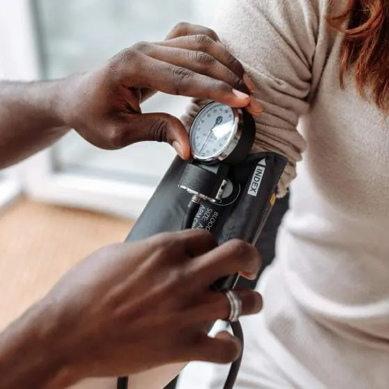 A medical professional tests the blood pressure of a patient.