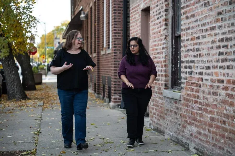 Two staff members of the Public Health Institute of Metropolitan Chicago walk down a neighborhood street.