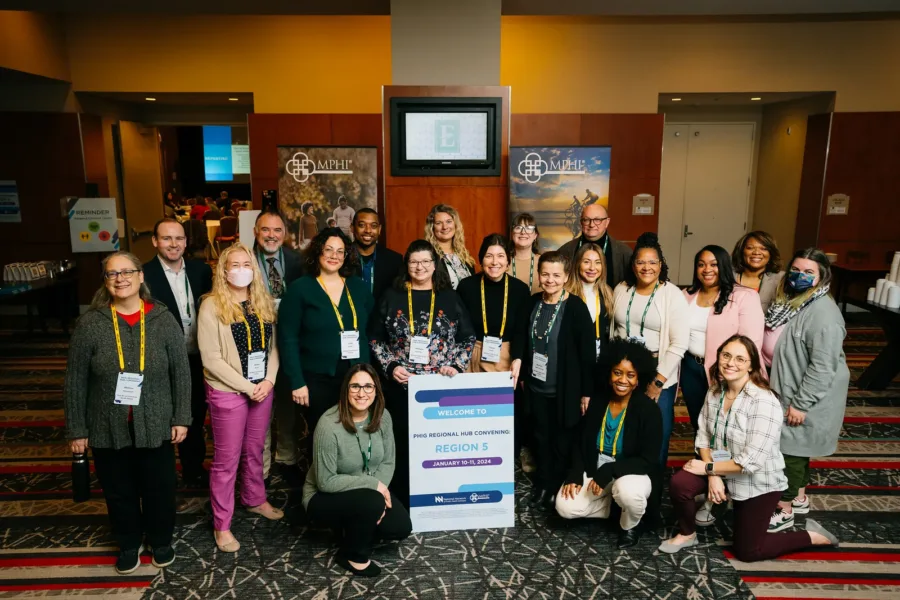 The MPHI team and key partners pose with a Region 5 sign.