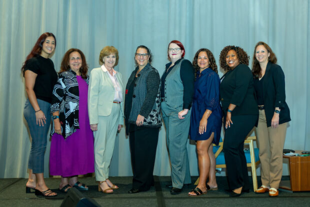 Attendees pose in a row.