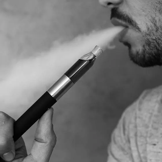 A man exhales after using a vaping device.