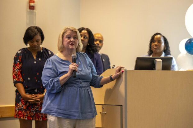 A woman speaks into a microphone at the Emerging Leaders Academy closing ceremony