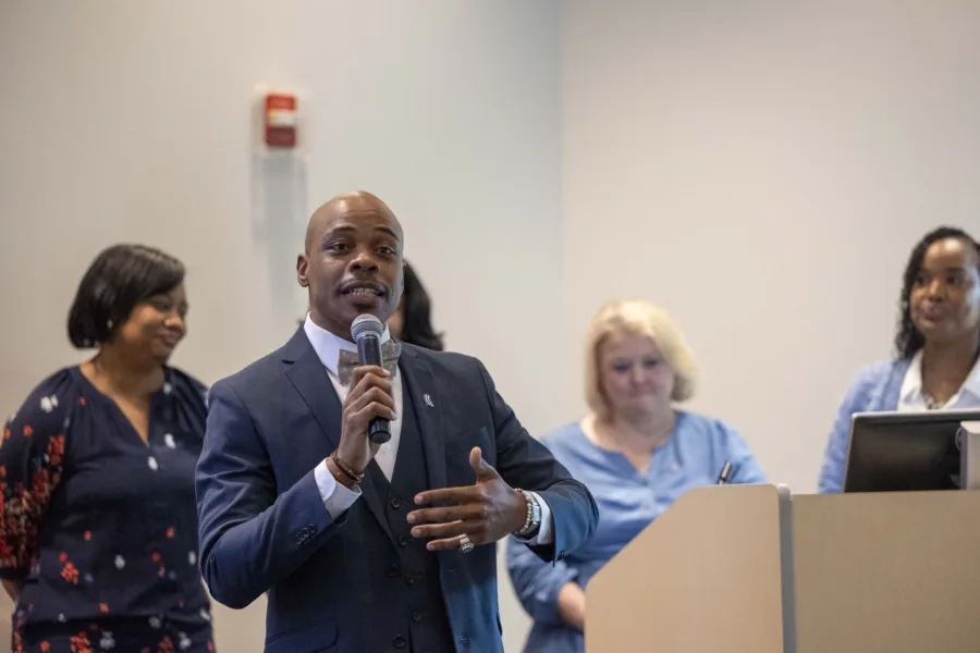 A man speaks into a microphone at the Emerging Leaders Academy closing ceremony