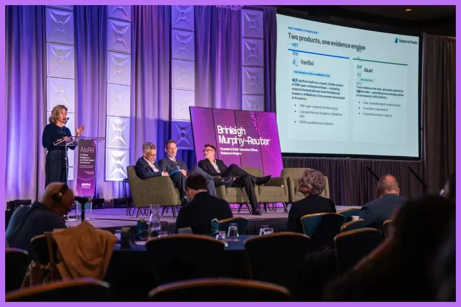 A panel discussion takes place on the main stage at the AIxPH conference.